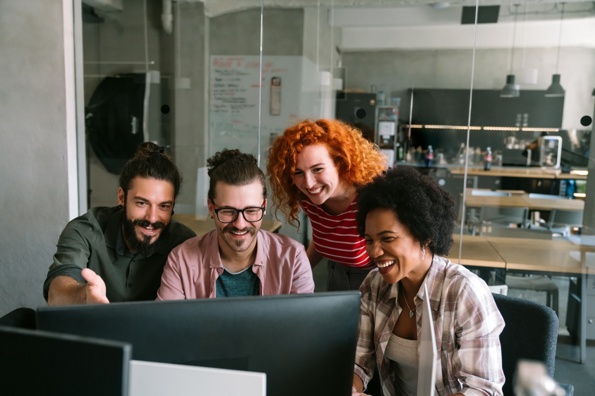 A group collaborating around a computer during a hands-on class